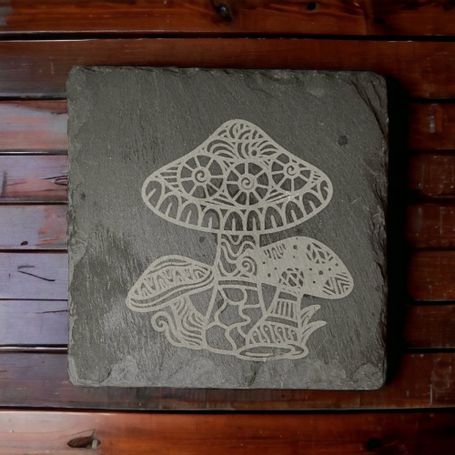 4 inch slate coaster with a mandala mushroom design engraved on it.